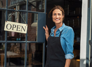 Mujer con camisa azul abriendo su negocio