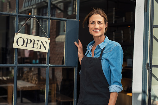 Mujer con camisa azul abriendo su negocio